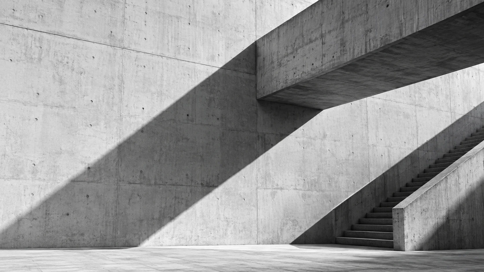 Intersecting pale concrete architectural planes with sculptural shadows